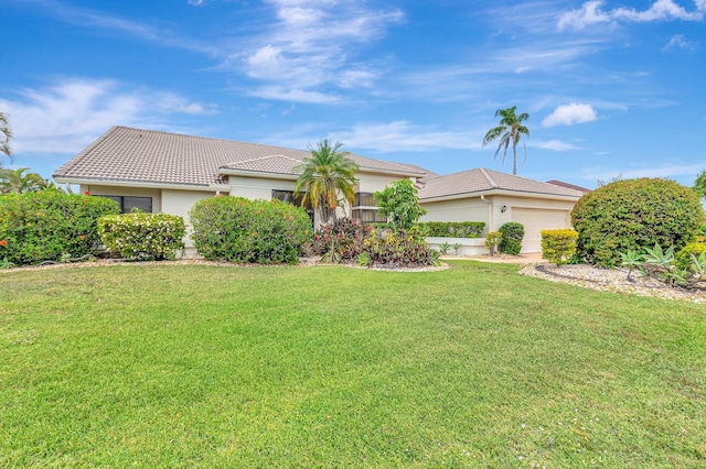 ranch-style home featuring a tiled roof, stucco siding, a front lawn, and a garage