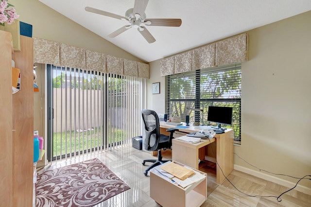 office space featuring baseboards, ceiling fan, vaulted ceiling, and a wealth of natural light