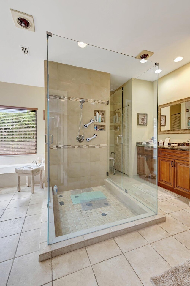 bathroom with tile patterned floors, a shower stall, a garden tub, and vanity