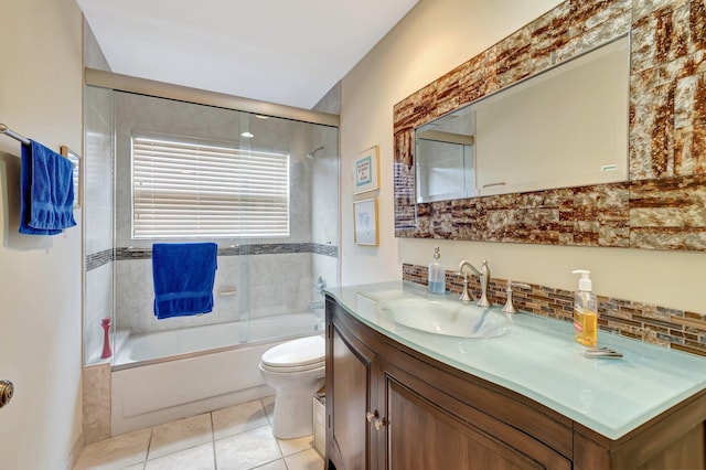 full bathroom with backsplash, tile patterned floors, vanity, toilet, and shower / bath combination with glass door
