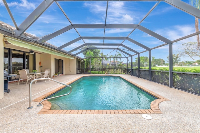 outdoor pool with a lanai, a ceiling fan, and a patio