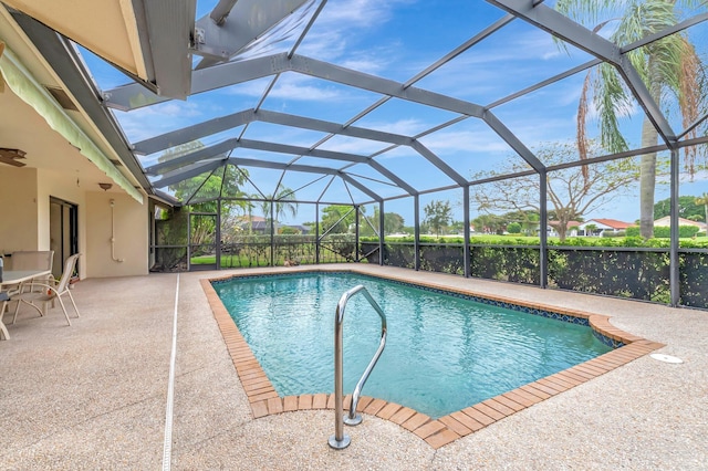 outdoor pool featuring glass enclosure and a patio area