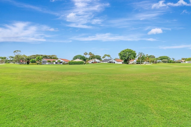 view of community featuring golf course view and a yard