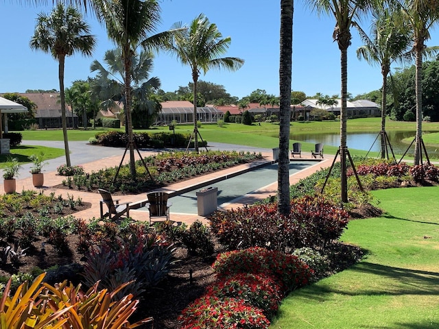 view of home's community featuring a lawn, a water view, and a residential view