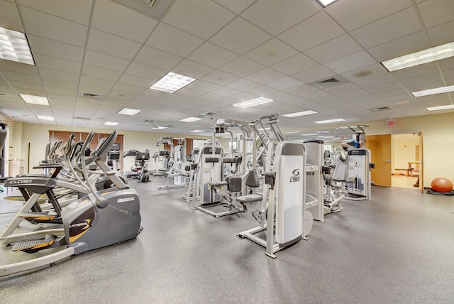 gym with a paneled ceiling and visible vents