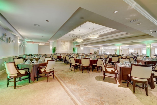 dining room featuring visible vents, carpet flooring, a tray ceiling, and ornamental molding