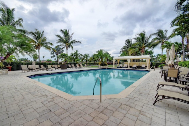 community pool with a patio and fence