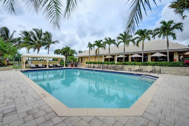 community pool featuring fence, a gazebo, and a patio area