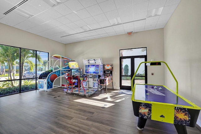 rec room with baseboards, a drop ceiling, and wood finished floors