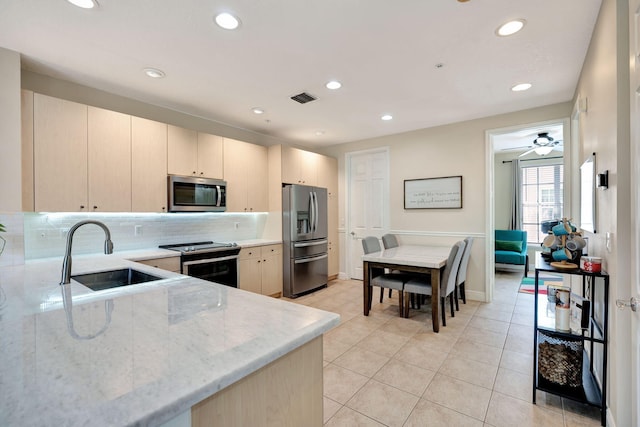 112 Osceola Ln, Jupiter, FL 33458 - kitchen featuring a sink, light stone counters, stainless steel appliances, and recessed lighting