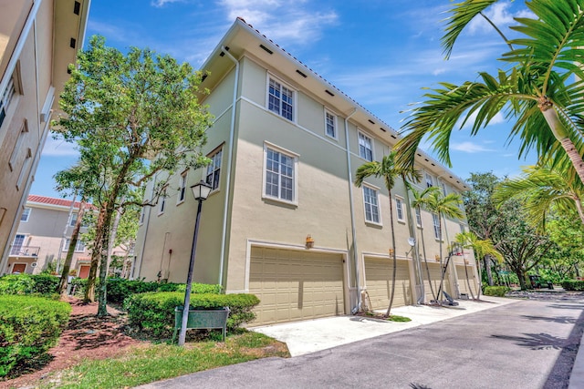 112 Osceola Ln, Jupiter, FL 33458 - view of side of home with an attached garage, driveway, and stucco siding