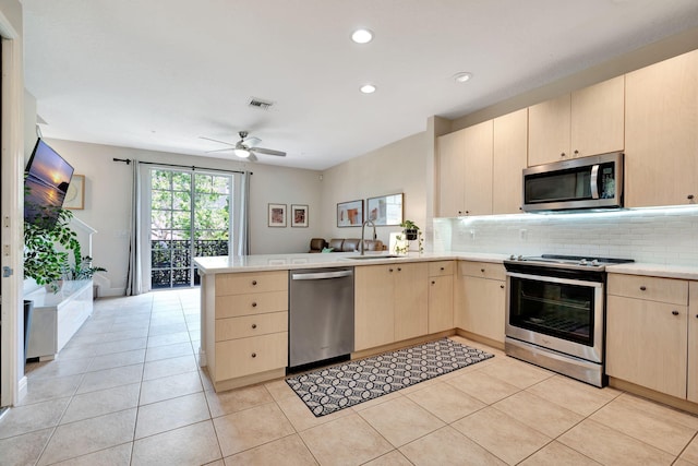 112 Osceola Ln, Jupiter, FL 33458 - kitchen with light brown cabinetry, appliances with stainless steel finishes, a sink, light countertops, and a peninsula