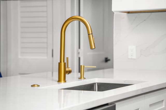 303/305 De Carie, Delray Beach, FL 33444 - details featuring light countertops, white cabinetry, and a sink