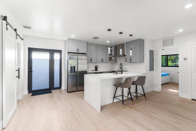303/305 De Carie, Delray Beach, FL 33444 - kitchen with wall chimney range hood, gray cabinetry, stainless steel refrigerator with ice dispenser, and visible vents