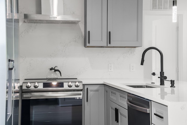 303/305 De Carie, Delray Beach, FL 33444 - kitchen featuring wall chimney exhaust hood, a sink, backsplash, gray cabinetry, and stainless steel appliances