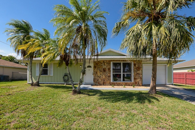 1831 SW Notre Dame Ave, Port Saint Lucie, FL 34953 - ranch-style home featuring an attached garage, central AC unit, asphalt driveway, and stone siding