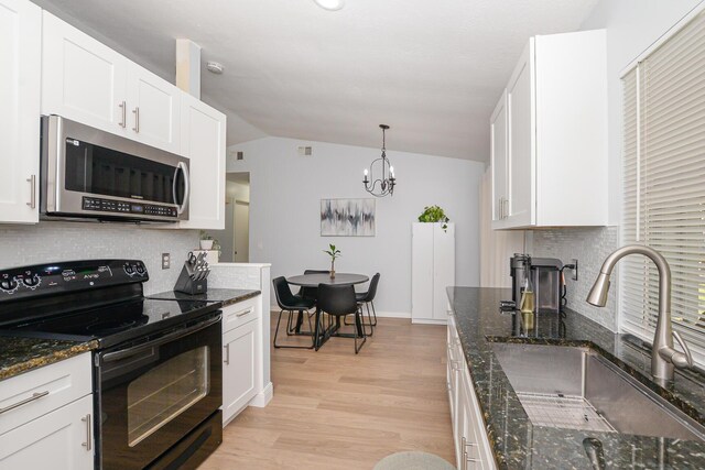 1831 SW Notre Dame Ave, Port Saint Lucie, FL 34953 - kitchen with stainless steel microwave, black range with electric stovetop, vaulted ceiling, a sink, and decorative backsplash