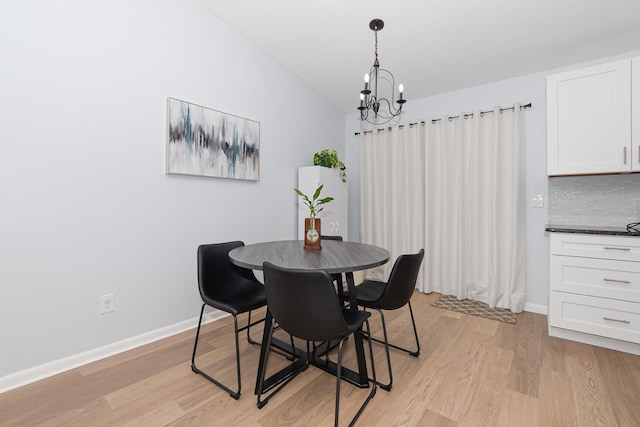 1831 SW Notre Dame Ave, Port Saint Lucie, FL 34953 - dining room with light wood-style flooring, a chandelier, baseboards, and vaulted ceiling