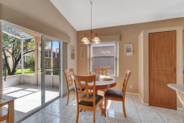 dining space featuring light tile patterned floors, lofted ceiling, a healthy amount of sunlight, and a notable chandelier