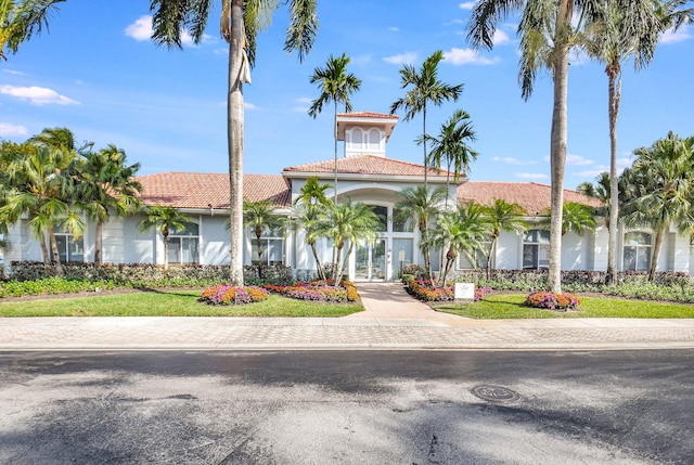 mediterranean / spanish-style house with stucco siding and a tiled roof