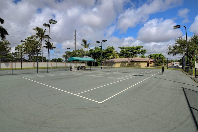 view of tennis court with fence and community basketball court