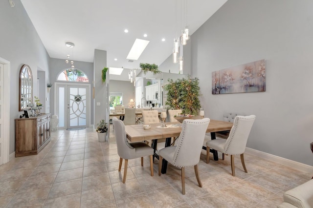 dining room with recessed lighting, a skylight, baseboards, and high vaulted ceiling