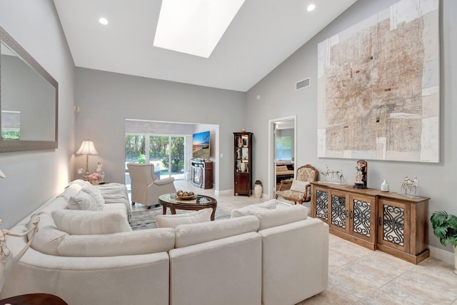 living area featuring visible vents, a skylight, high vaulted ceiling, baseboards, and light tile patterned flooring