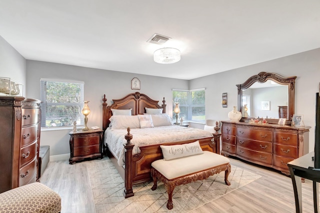 bedroom with baseboards, visible vents, and light wood-type flooring