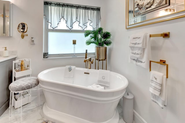 full bathroom featuring a freestanding bath, baseboards, vanity, and marble finish floor