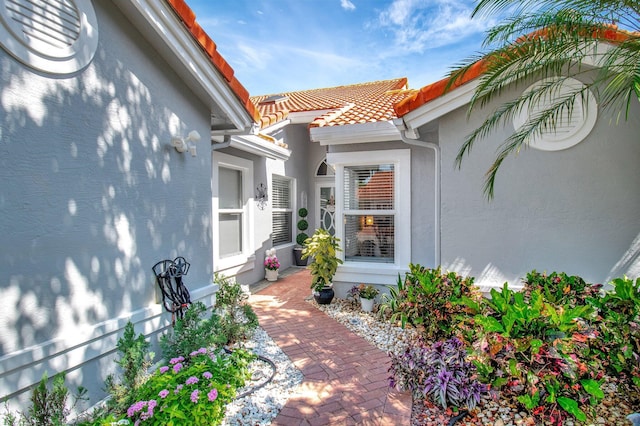 exterior space with a tiled roof and stucco siding