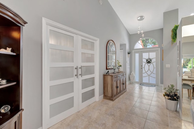 entryway with baseboards, plenty of natural light, french doors, and light tile patterned flooring