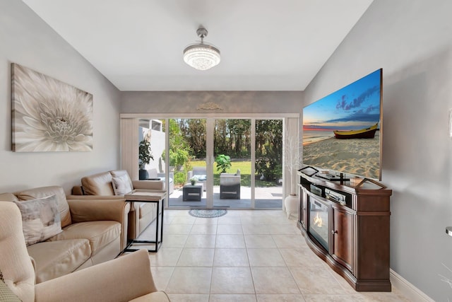 living area with baseboards, light tile patterned flooring, and vaulted ceiling