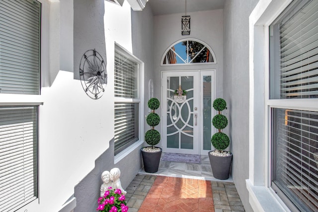 property entrance featuring a porch and stucco siding