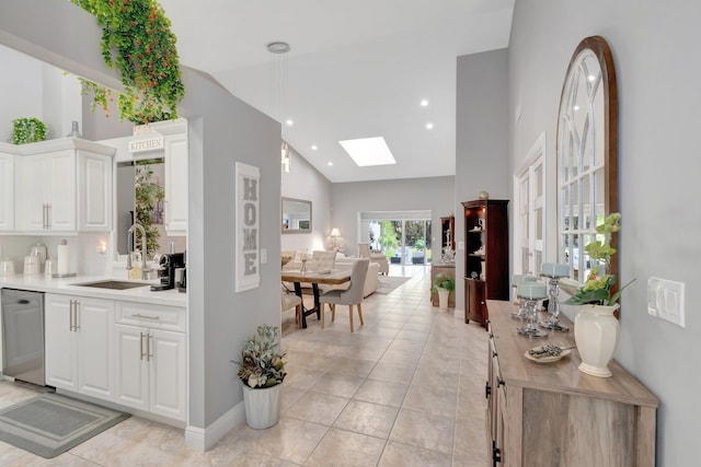 bar featuring a sink, dishwasher, high vaulted ceiling, recessed lighting, and a skylight