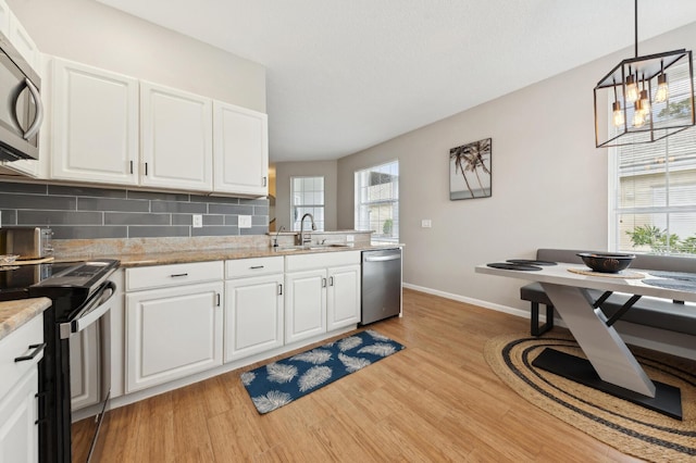 175 Harbor Lake Cir, Greenacres, FL 33413 - kitchen with light wood-style flooring, a sink, appliances with stainless steel finishes, and baseboards