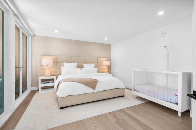 bedroom with recessed lighting, wood finished floors, and baseboards