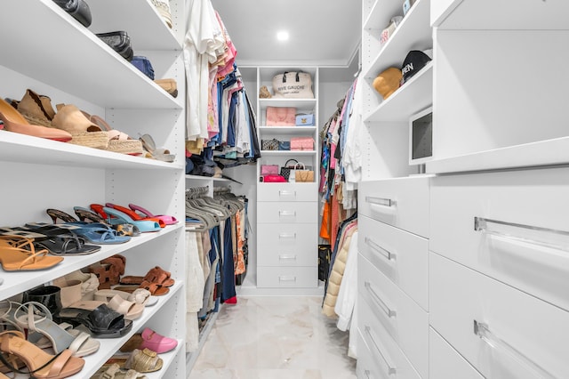 walk in closet with marble finish floor