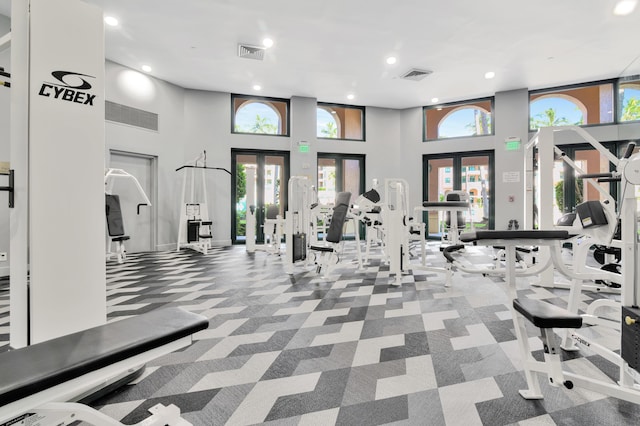 workout area with visible vents, carpet floors, french doors, and a towering ceiling