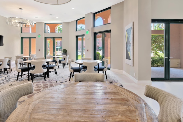 dining room featuring recessed lighting, a chandelier, baseboards, french doors, and a towering ceiling