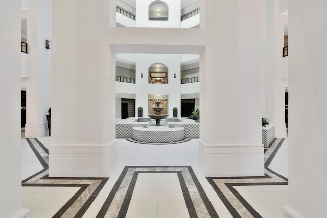 entryway with baseboards and a towering ceiling