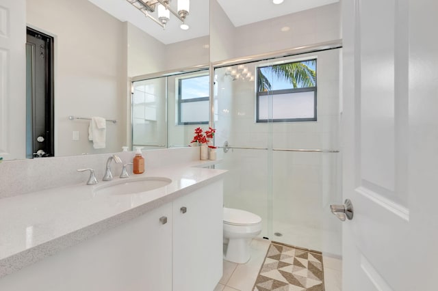 bathroom with vanity, tile patterned flooring, a stall shower, and toilet