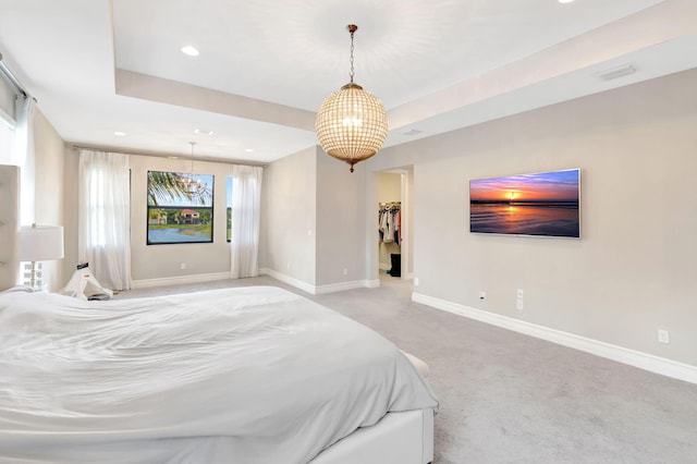 bedroom featuring baseboards, a walk in closet, light colored carpet, recessed lighting, and a chandelier