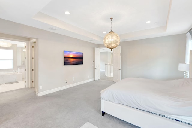 bedroom with light colored carpet, baseboards, and a tray ceiling