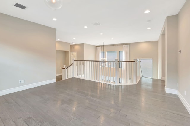 unfurnished room with visible vents, recessed lighting, baseboards, and wood finished floors