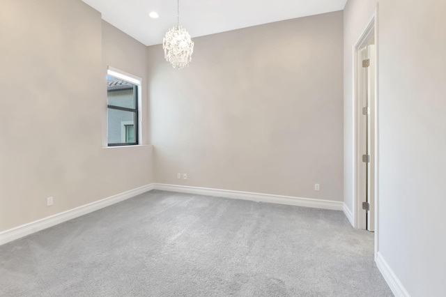 empty room featuring baseboards, carpet, recessed lighting, and a chandelier