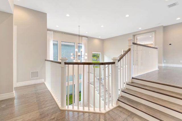 staircase featuring visible vents, plenty of natural light, and wood finished floors