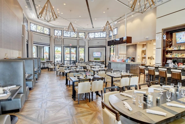 dining room featuring recessed lighting, a towering ceiling, and a chandelier