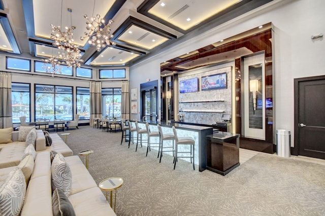 bar featuring a high ceiling, a community bar, coffered ceiling, carpet, and a notable chandelier