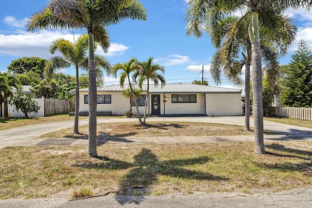 ranch-style home featuring fence and concrete driveway
