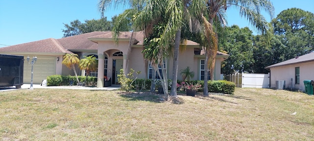 ranch-style home with an attached garage, a front lawn, central AC, and stucco siding